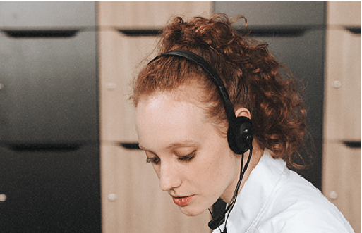A woman is wearing a headset to provide support ticket service.